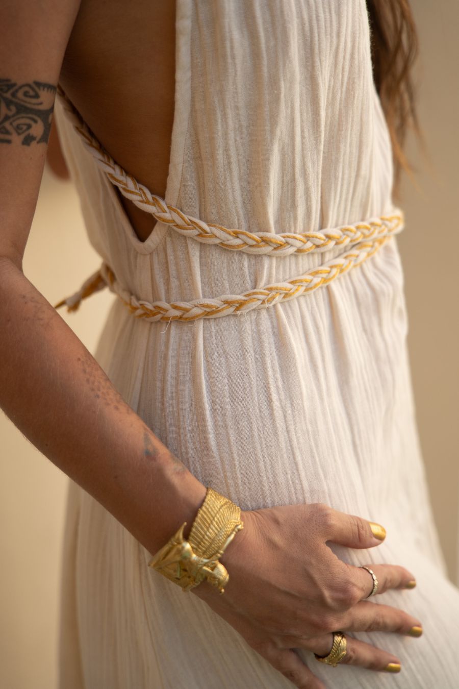 detail of golden Eri silk braids and charms on the Delphi Dress