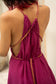 Magenta halter neck dress with braided straps on a blurred background
