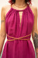 Close-up of a person wearing the Delphi dress in magenta dress with a gold chain detail.